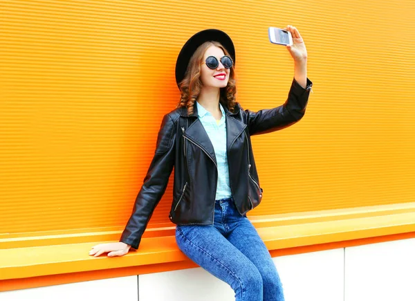 Mulher de moda está tirando uma foto em um smartphone em colorido ou — Fotografia de Stock