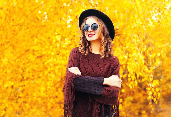 黒い丸い帽子、ニットのポンチョで秋ファッションの笑顔の女性 — ストック写真