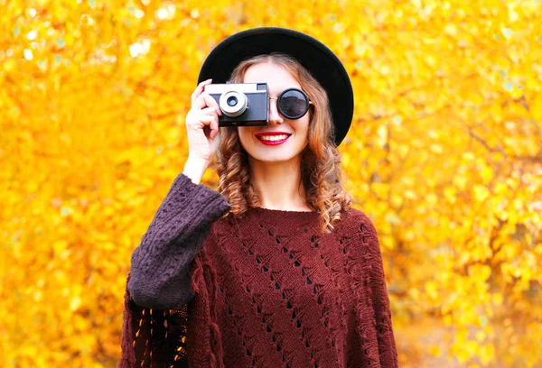 Открытая модная улыбающаяся женщина с ретро-камерой в черном круглом. — стоковое фото
