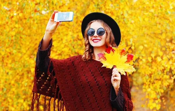 Осенняя мода улыбающаяся молодая женщина фотографирует автопортрет — стоковое фото