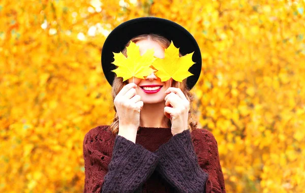Jesienny portret uśmiechający się kobieta ukrywa jej liści klonu żółte oczy — Zdjęcie stockowe