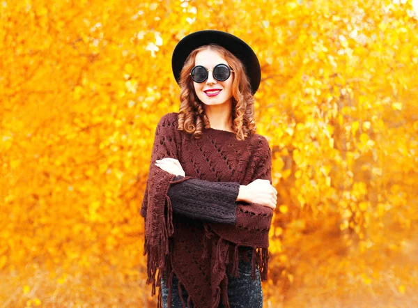 Mode automne femme souriante en chapeau rond noir, poncho tricoté — Photo