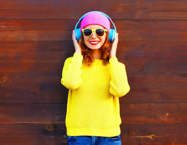 Moda menina sorridente ouve música em fones de ouvido, pi colorido — Fotografia de Stock