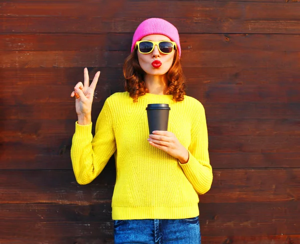 Модная женщина с чашкой кофе в цветной одежде на деревянной бочке — стоковое фото
