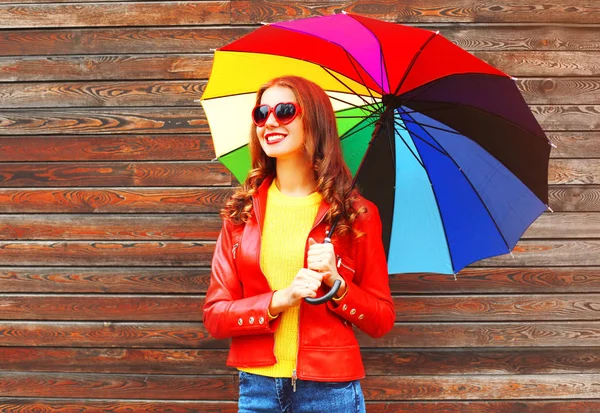 Retrato mulher sorridente com guarda-chuva colorido no outono sobre woo — Fotografia de Stock