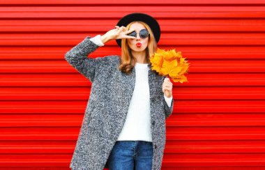 Kırmızı dudaklar ve sarı akçaağaç yaprakları ile sonbahar genç kadın moda