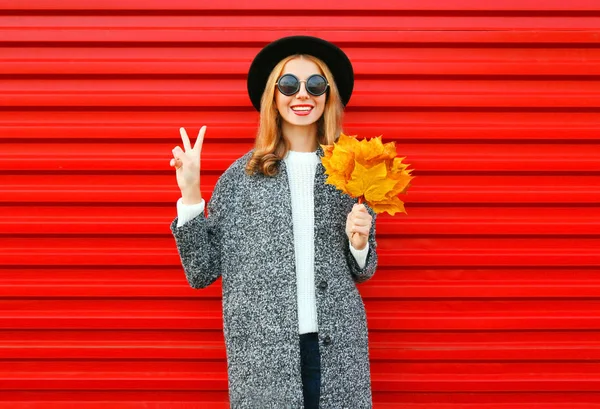 Mode Herbst cooles Mädchen mit gelben Ahornblättern auf rotem Rücken — Stockfoto