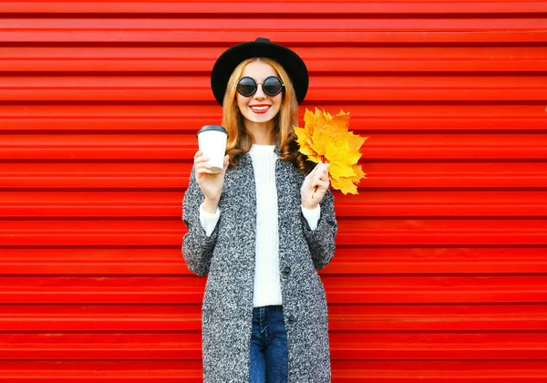 Moda outono mulher sorridente com xícara de café e bordo amarelo le — Fotografia de Stock