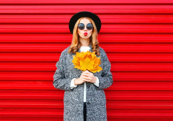 Mode Herbst junge Frau mit roten Lippen hält gelbes Ahornblatt — Stockfoto
