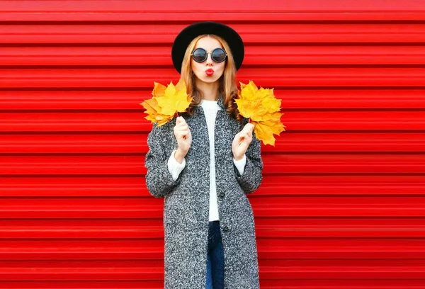 Mode automne jeune femme aux lèvres rouges tient feuille d'érable jaune — Photo
