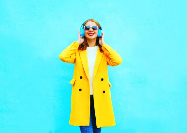 Moda mujer bastante sonriente escucha música en los auriculares en un — Foto de Stock