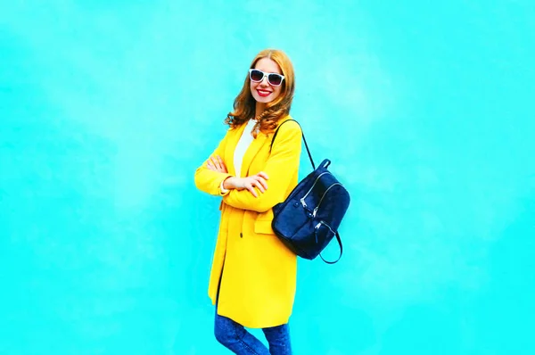 Модная симпатичная женщина в желтой куртке с рюкзаком на плече — стоковое фото