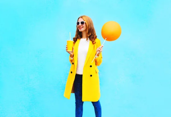 Moda bonita mujer sonriente con globo de aire naranja sostiene taza o — Foto de Stock