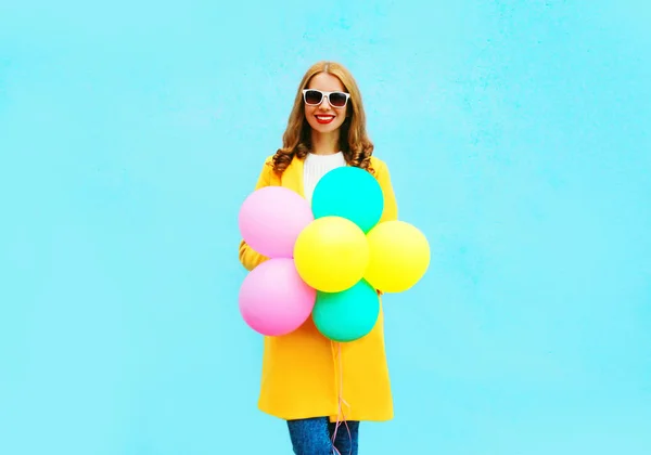 Mode leende kvinna med en luft ballonger i en gul rock på en — Stockfoto