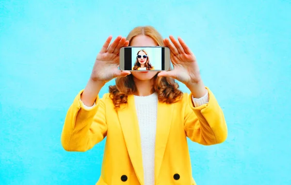 Mujer de moda toma foto autorretrato en el teléfono inteligente en azul — Foto de Stock