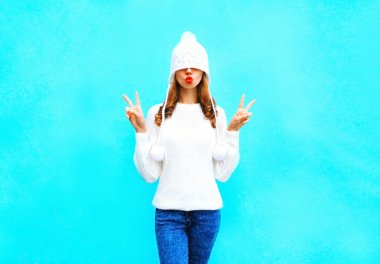 Kırmızı dudaklar ile mutlu genç kadın bir örme h öpmek bir hava yapar