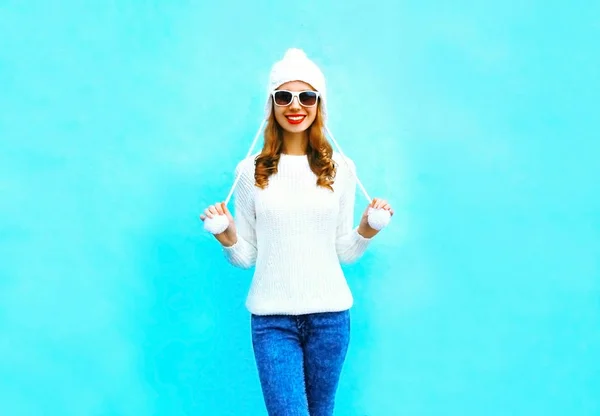 Mulher sorridente em camisola de malha e chapéu em um fundo azul em — Fotografia de Stock