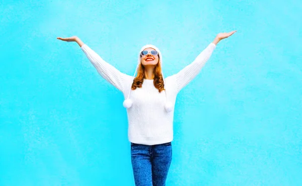 Feliz mujer sonriente en suéter de punto y sombrero en un backgro azul — Foto de Stock