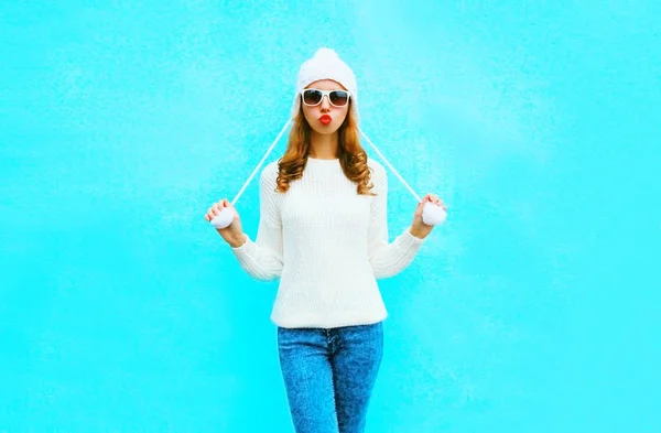Kvinna i stickad tröja, hatt på en blå bakgrund i staden — Stockfoto