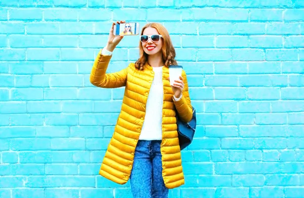 Sorrindo mulher tira uma foto auto retrato no smartphone com c — Fotografia de Stock