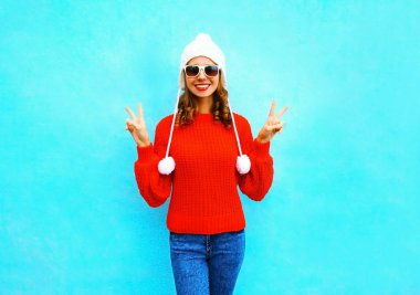 Örme kazak ve mavi bir backg şapka gülümseyen kadın moda