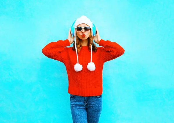 Bella donna in maglione rosso, ascolta musica in hea wireless — Foto Stock