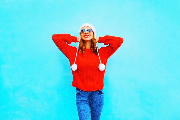 Feliz mulher sorridente em camisola de malha vermelha e chapéu em um bac azul — Fotografia de Stock