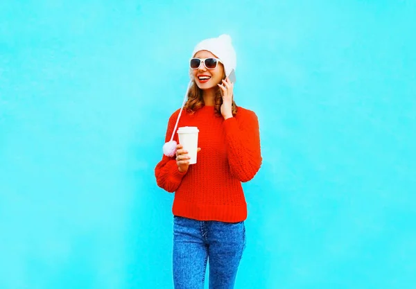 Giovane donna sorridente parla su uno smartphone tiene tazza di caffè su un — Foto Stock