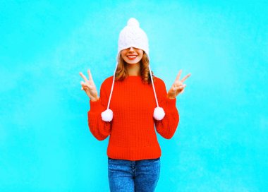 Mutlu neşeli kadın örgü şapka, kırmızı kazaklı bir mavi bac üzerinde