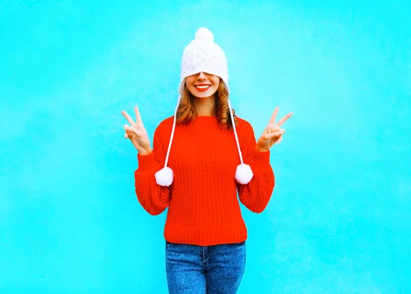 Feliz mujer alegre en un sombrero de punto, suéter rojo en un bac azul —  Fotos de Stock