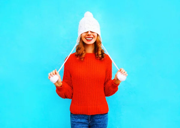 Feliz mujer sonriente en un sombrero de punto, suéter rojo en una espalda azul — Foto de Stock