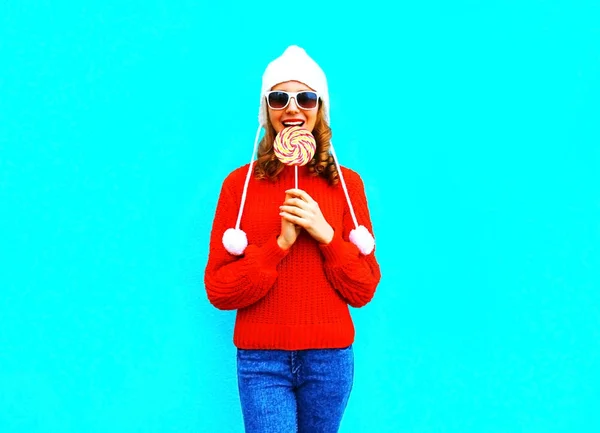 Portret bardzo uśmiechnięta kobieta gryzie lizak w czerwony sweter sw — Zdjęcie stockowe