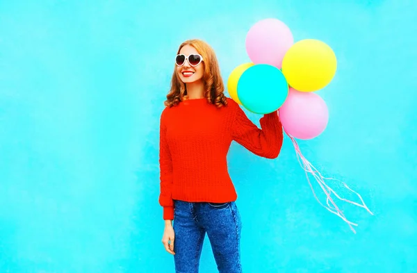 Mode ganska leende kvinna håller en färgglad luft ballonger på en — Stockfoto