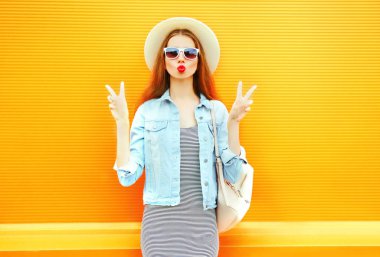 Genç ve güzel kadın portre yapmak üzerinde turuncu backgro öpmek bir hava