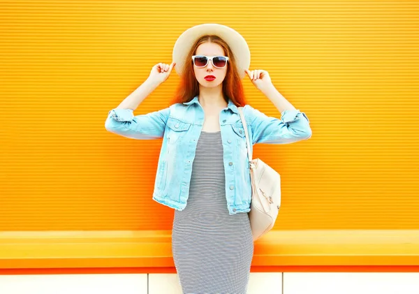 Moda mujer bonita en un sombrero de paja sobre un fondo naranja — Foto de Stock