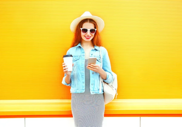 Lachende vrouw mode met behulp van een smartphone houdt het koffiekopje op een o — Stockfoto