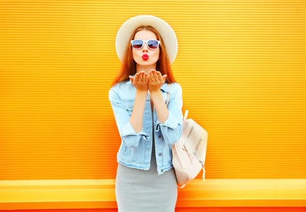 Portrait jolie jeune femme envoie un baiser d'air sur un backgr orange — Photo