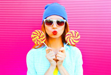 bir lolipop geçiriyor tatlı kadın tutan iki eğlenceli renkli pink