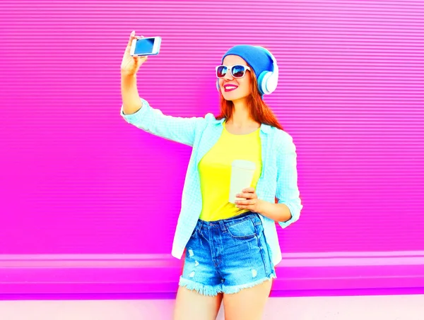 Модная улыбающаяся женщина делает автопортрет на смартфоне — стоковое фото