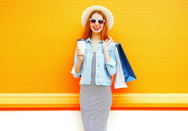 Mujer sonriente de moda con una taza de café, bolsas de compras, paja ha —  Fotos de Stock