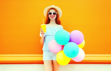 Gülümseyen kadın moda bir hava colorf bir meyve suyu bardağı tutan