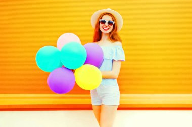 Bir hava renkli balonları bir portakal ile gülümseyen kadın moda 