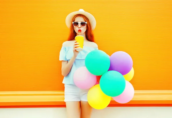 Mujer de moda bebe un jugo de frutas sostiene un globo colorido aire — Foto de Stock