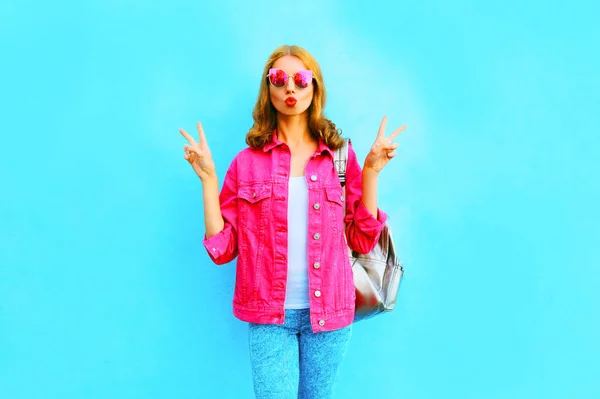 Модная красавица делает воздушный поцелуй в розовой джинсовой куртке — стоковое фото