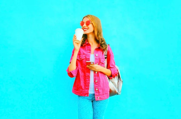Moda mulher sorridente está usando smartphone em jaqueta de ganga rosa h — Fotografia de Stock