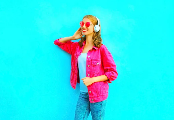 Mode leende kvinna lyssnar på musik i en trådlösa hörlurar — Stockfoto
