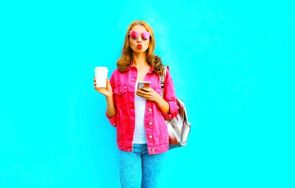 Modefrau hält Smartphone, Kaffeetasse in rosa Jeansjacke, — Stockfoto