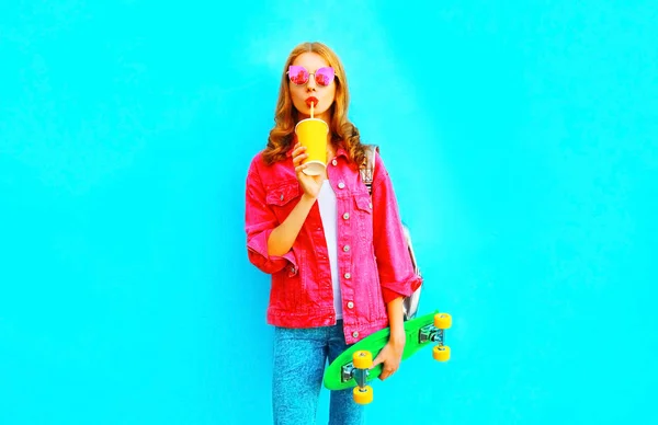 Мода молода жінка п'є фруктовий сік тримає скейтборд Wearin — стокове фото