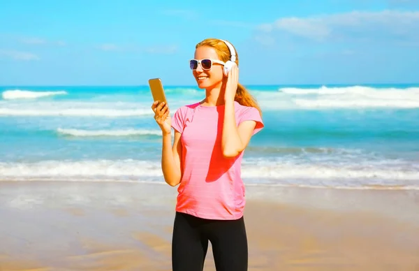 Mulher fitness ouve música em fones de ouvido sem fio com sma — Fotografia de Stock