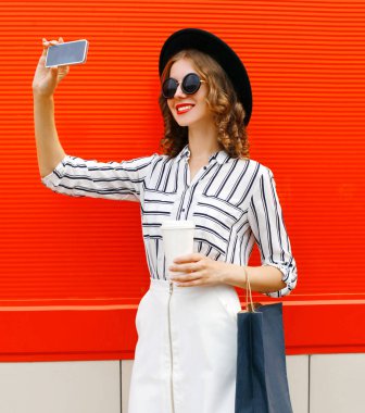 Güzel, genç, gülümseyen bir kadın. Akıllı fonla selfie çekiyor.